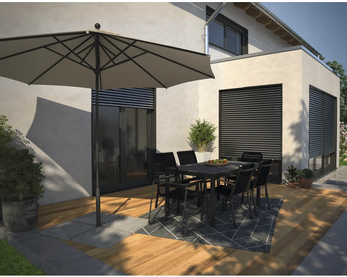 Außenbereich mit Sonnenschirm, Gartentisch und Stühlen auf einer Terrasse.
