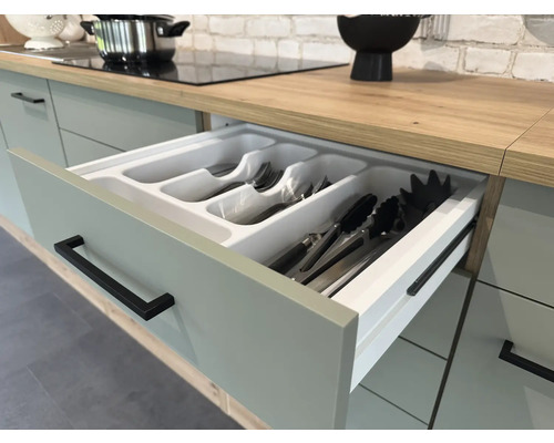 Küchenschublade mit Besteckeinsatz in einem hellen Küchenraum.