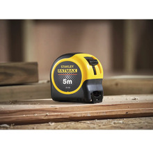 Mètre à ruban Stanley Fatmax d'une longueur de 5 mètres sur une poutre en bois