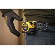 Mètre ruban Stanley Fatmax d'une longueur de cinq mètres fixé à la ceinture du pantalon