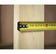 Un mètre ruban jaune de Stanley mesure une pièce de bois.