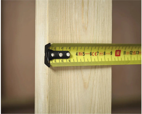 Un mètre ruban jaune de Stanley mesure une pièce de bois.