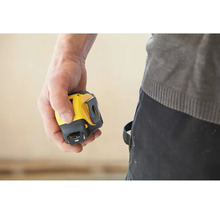 Main tenant un mètre ruban jaune et noir.