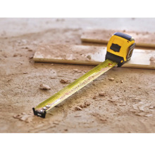 Mètre à ruban jaune sur le sol