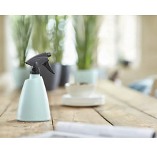 Sprühflasche aus Kunststoff mit Sprühkopf auf Holztisch