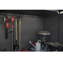 Intérieur d'abri de jardin avec outils de jardinage, boîtes de rangement et établi