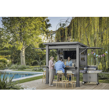Szene mit einer grauen Gartenbar mit Grill, an der drei Personen stehen und sitzen.