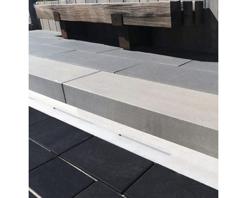 Terrasse mit Pflastersteinen, Stufen und einer Holzsitzbank.