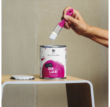 Farbdose mit Lackfarbe und Pinsel der Marke Miss Pompadour auf einem Tisch