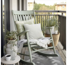 Balkonszene mit Schaukelstuhl, Kissen, Decke, Pflanzen und Beistelltisch für entspannte Momente im Freien