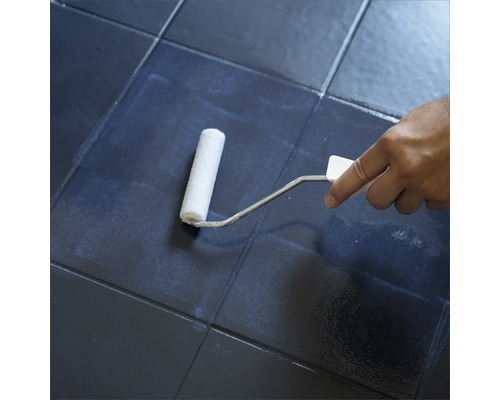 Fliesen werden mit einer Farbwalze gestrichen.