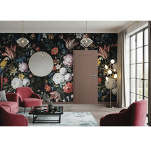 Salon avec papier peint floral, porte, miroir, suspensions, lampadaire, tapis, table basse et fauteuils