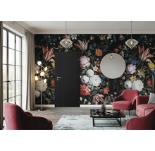 Salon élégant avec papier peint floral, porte, fauteuils, canapé et éclairage