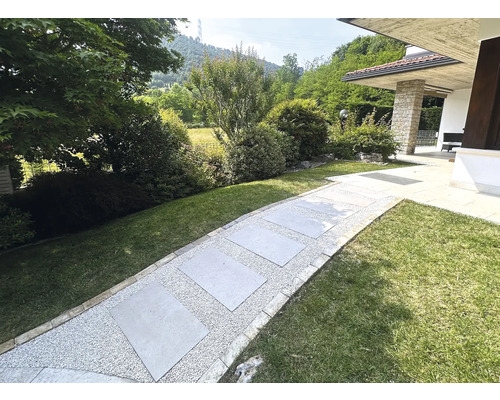 Chemin de jardin avec dalles de pierre et gravier entre les espaces verts