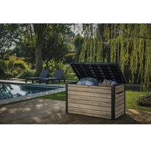 Garten Szene mit einer geöffneten Aufbewahrungsbox aus Kunststoff auf einer Terrasse mit Pool und Liegen