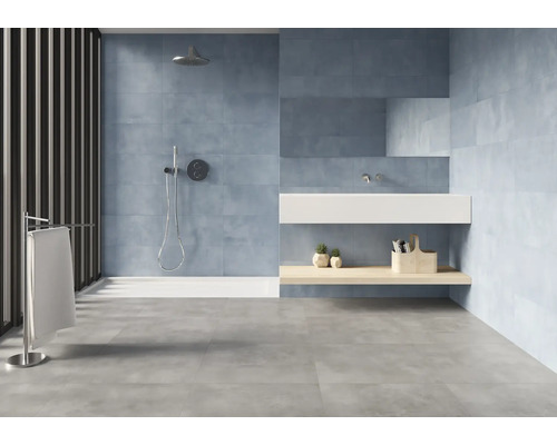 Salle de bain moderne avec douche, lavabo et carrelage gris.