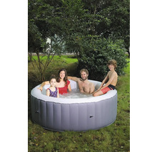 Une famille se détend dans un jacuzzi gonflable dans le jardin.