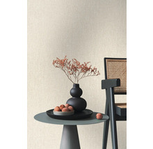 Dekorative Szene mit Tisch, Vase, Dekoration und Stuhl vor einer strukturierten Wand