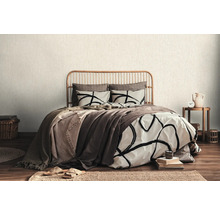 Schlafzimmer mit Bett, Bettwäsche und Holzbettrahmen