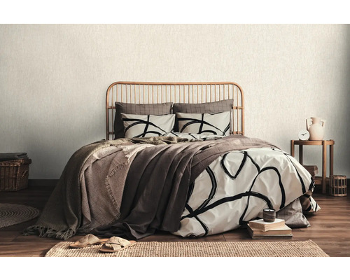 Schlafzimmer mit Bett, Bettwäsche und Holzbettrahmen