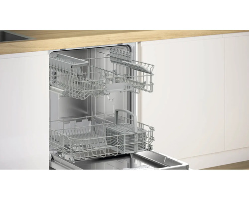 Lave-vaisselle ouvert avec paniers sortis dans une cuisine moderne.