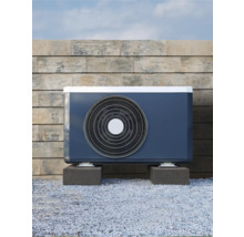 Ausseneinheit einer Luft-Wasser-Wärmepumpe vor einer Steinmauer