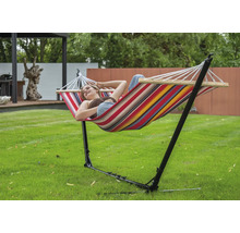 Femme se détend dans un hamac avec cadre en acier dans le jardin