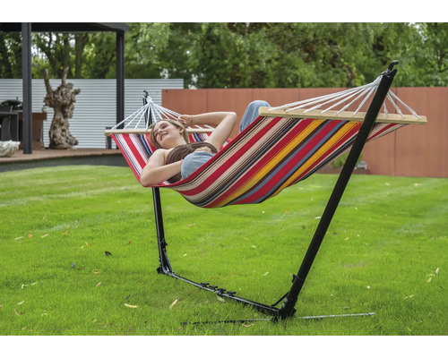 Femme se détend dans un hamac avec cadre en acier dans le jardin