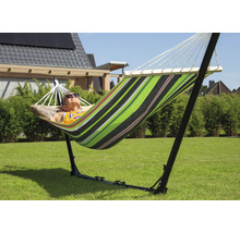 Un homme se détend dans un hamac rayé avec support dans le jardin.