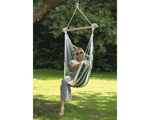 Une femme se détend dans un hamac suspendu dans le jardin