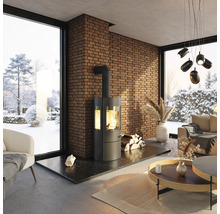 Salon avec poêle à bois, mur en briques et vue sur un paysage enneigé