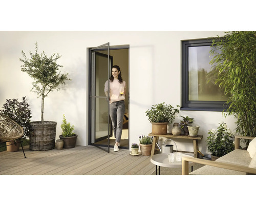 Terrasse avec plantes, meubles de jardin, porte moustiquaire et fenêtre pour une ambiance chaleureuse.