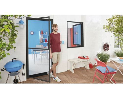 Terrasse avec barbecue, table et chaises, accessible par une porte-fenêtre avec un homme