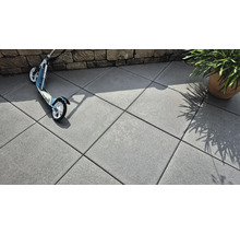 Dalles en béton posées à l'extérieur avec trottinette et plante