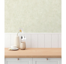 Innenraumszene mit einer Arbeitsplatte, Geschirr und einer Vase mit einer Blume vor einer Wand