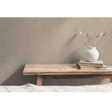 Beige Strukturtapete im Innenraum mit Holztisch, Büchern und Dekoration