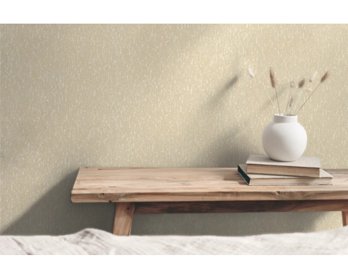 Wand mit Vliestapete, Bücher und Blumenvase auf einem Holztisch