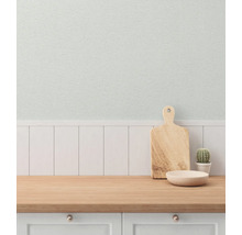 Küchenszene mit Schneidebrett, Schale und Kaktus auf einer hölzernen Arbeitsplatte vor einer Wand mit Holzvertäfelung und Tapete