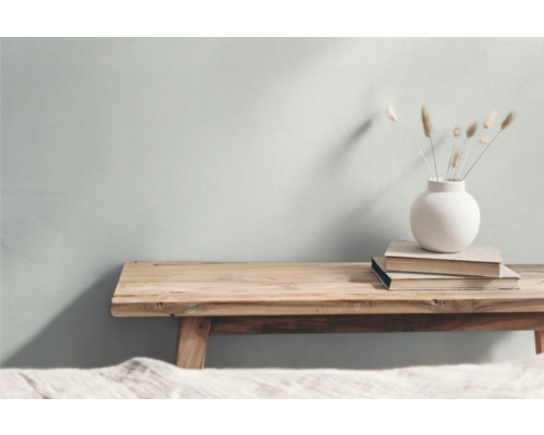 Dekorative Szene mit einer Holzbank, Büchern und einer Vase mit Ziergras