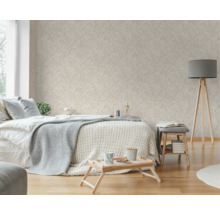 Chambre à coucher lumineuse avec papier peint à motifs, lit, lampadaire et parquet.