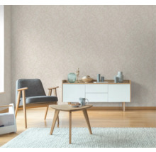 Wohnzimmer mit Sessel, Tisch, Kommode und gemusterter Tapete