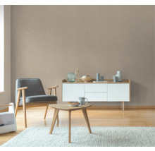 Wohnzimmer mit beiger Struktur Tapete, Sessel und Kommode