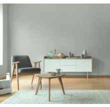 Wohnzimmer mit Sessel, Kommode, Tisch und Teppich in hellem Design