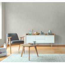 Wohnzimmer mit Sessel, Sideboard und Couchtisch auf einem Teppich