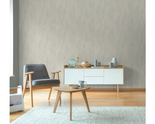 Wohnzimmer mit gemusterter Tapete, Sessel, Tisch und Kommode