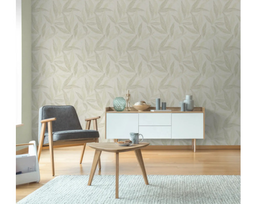 Wohnzimmer mit Blättertapete, Sessel, Tisch und Kommode