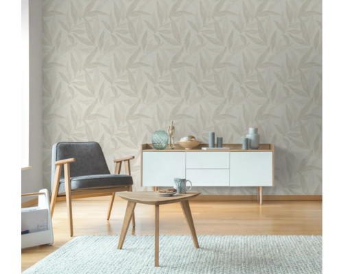 Wohnzimmer mit gemusterter Tapete, Sessel, Tisch und Kommode