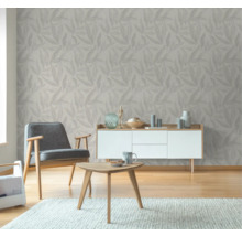 Wohnzimmer mit Blattmuster-Tapete, Sessel, Tisch und Kommode