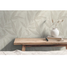 Wohnraum mit Blattmuster-Tapete, Holztisch, Büchern und Vase mit Dekoration