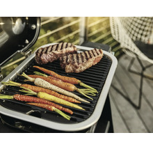 Barbecue avec steaks et carottes sur la grille